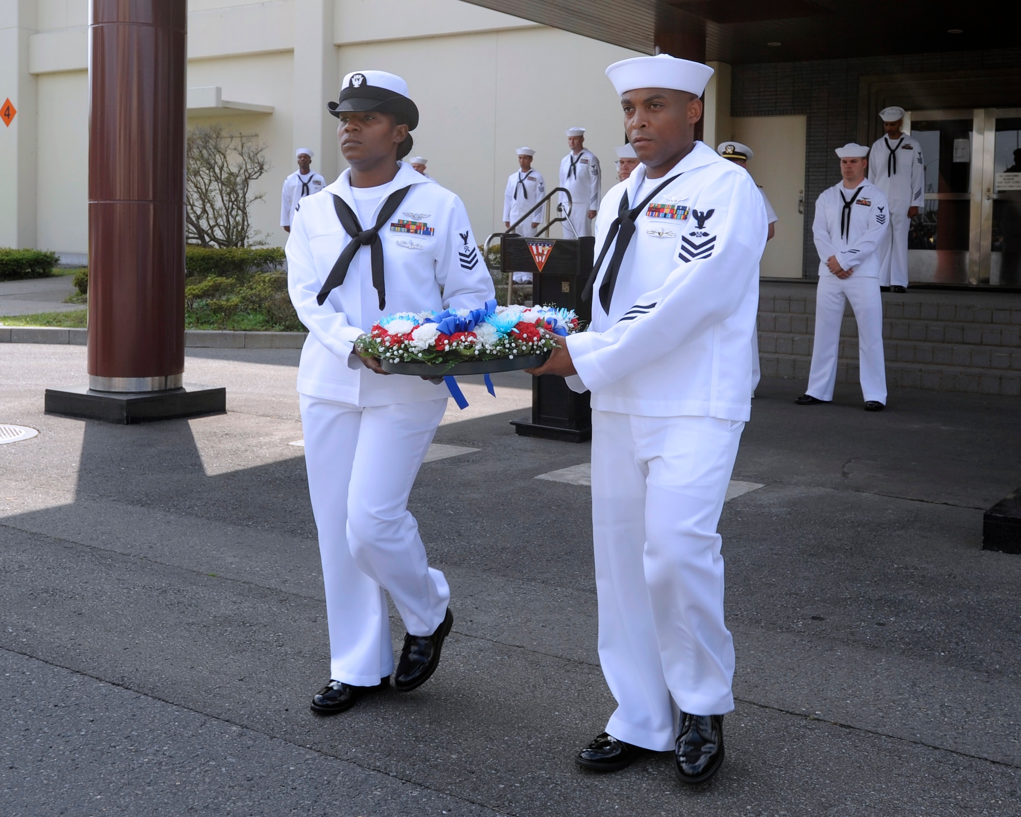 Chief (select)Aviation Boatswain's Mate (Handling) Shawn Leigh, foreground, from Norfolk, and Chief (select) Logistics Specialist Nicola Canada, a native of Lexington, Ky., carry a commemorative wreath during a 9/11 Remembrance Ceremony onboard Naval Air Facility Misawa, Japan, Sept. 11, 2012. The wreath will be laid at the foot of the U.S. flagpole to help commemorate the 11th anniversary of the Sept. 11, 2001 terrorist attacks. (U.S. Navy photo by Senior Chief Mass Communication Specialist Daniel Sanford/RELEASED)