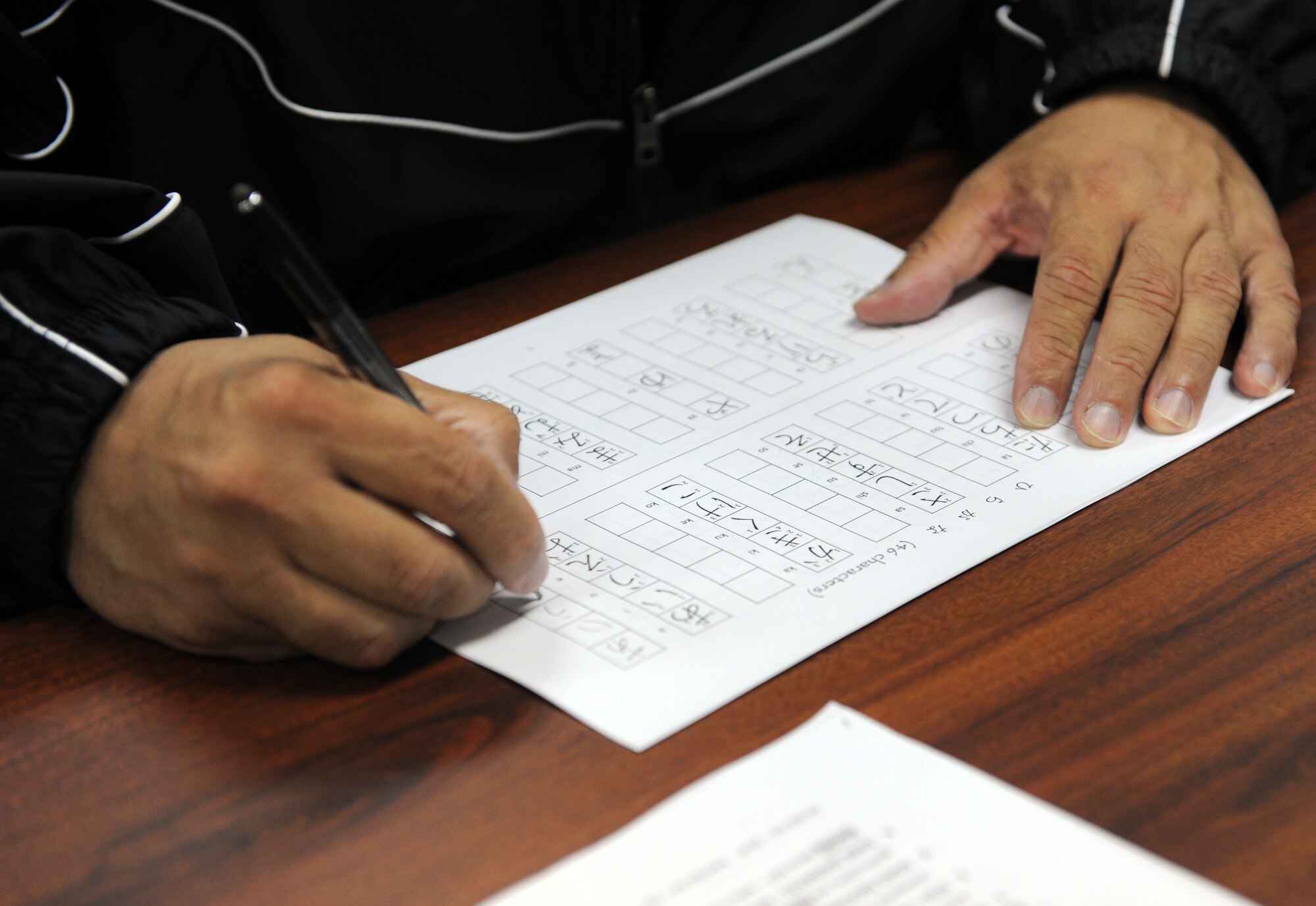 U.S. Navy Damage Controlman 1st Class Will Mayorga, Electronic Warfare Squadron 132, practices writing hiragana characters during his first session of Beyond Survival Japanese at Misawa Air Base, Japan, Sept. 10, 2012. In this session, class attendees practiced writing and saying the characters, days of the week, months and years as well as several other topics. If you’ve completed Survival Japanese and wish to give Beyond Survival Japanese a try, contact the Airman and Family Readiness Center at 226-4735 to register. (U.S. Air Force photo by Airman 1st Class Kia Atkins/Released) 