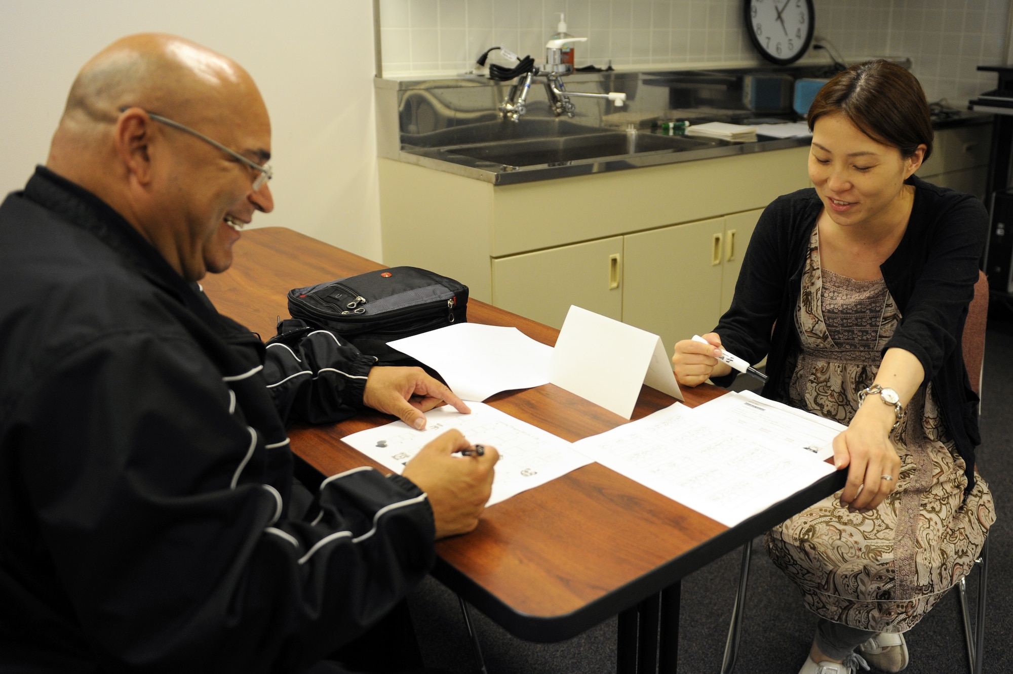 Mayu Aketo, right, Airman and Family Readiness Center multicultural program manager, instructs U.S. Navy Damage Controlman 1st Class Will Mayorga, Electronic Warfare Squadron 132, on how to write words in hiragana characters during the Beyond Survival Japanese class at Misawa Air Base, Japan, Sept. 10, 2012. The AFRC provides four sessions of Survival Japanese and three sessions of Beyond Survival Japanese. If you would like to attend these classes, call the AFRC at 226-4735 to sign up. (U.S. Air Force photo by Airman 1st Class Kia Atkins/Released)