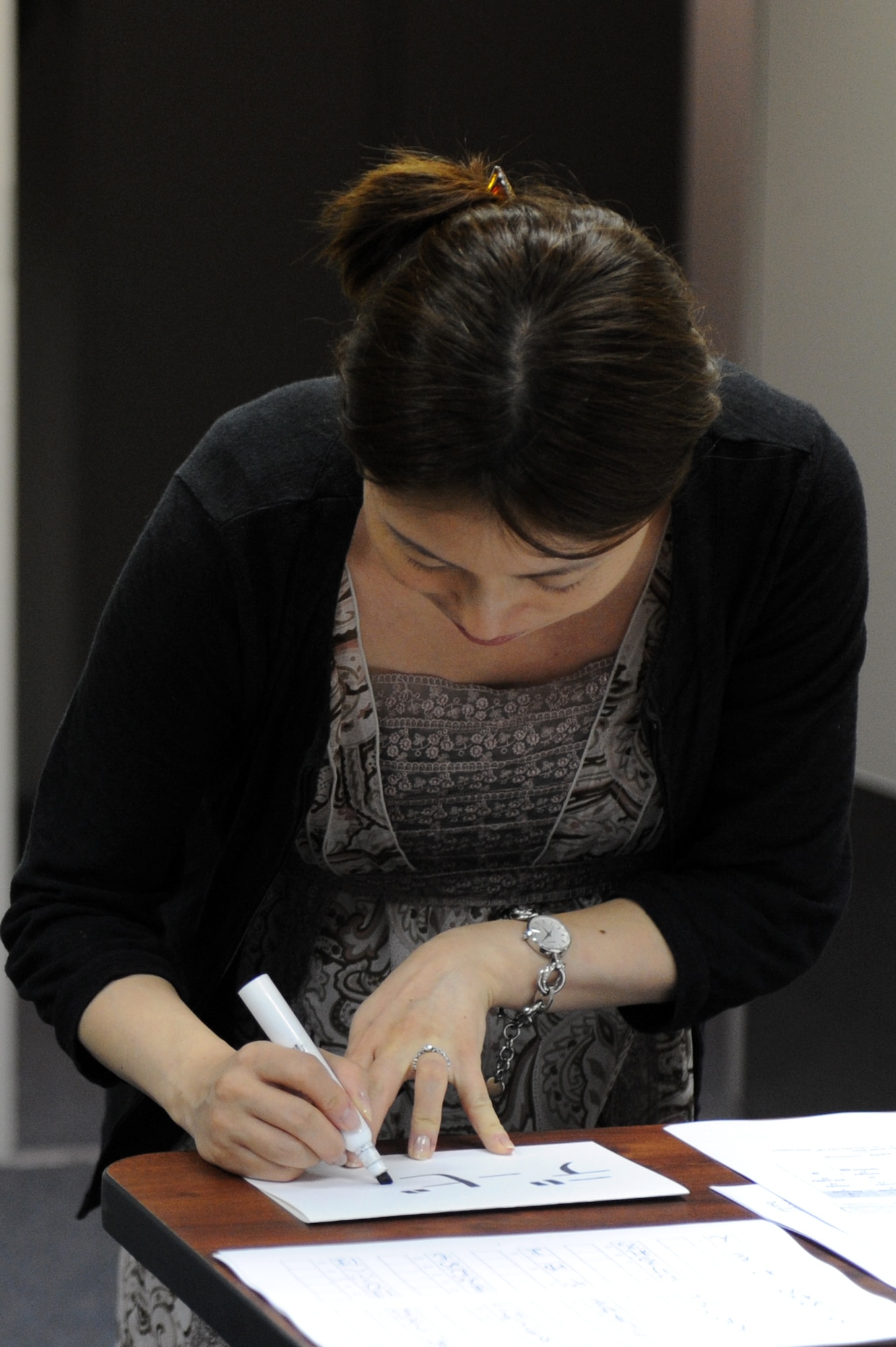 Mayu Aketo, Airman and Family Readiness Center multicultural program manager, writes a class attendee’s name in hiragana during session one of the Beyond Survival Japanese class at Misawa Air Base, Japan, Sept. 10, 2012. The three session long class can only be taken after completing the Survival Japanese class. If you would like to attend either class, contact the AFRC at 226-4735 to sign up. (U.S. Air Force photo by Airman 1st Class Kia Atkins/Released)