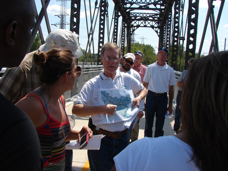 Greg Ajemian, senior engineer with the city of Dallas' Trinity River Corridor Project Office, talks to the U.S. Army Corps of Engineers Planning Associates Program class, Aug. 23, about the city’s Balanced Vision Plan and how the Trinity River channel has been moved through the years. He's speaking from atop an old Santa Fe trestle that was repurposed into a hike-bike trail river crossing.




