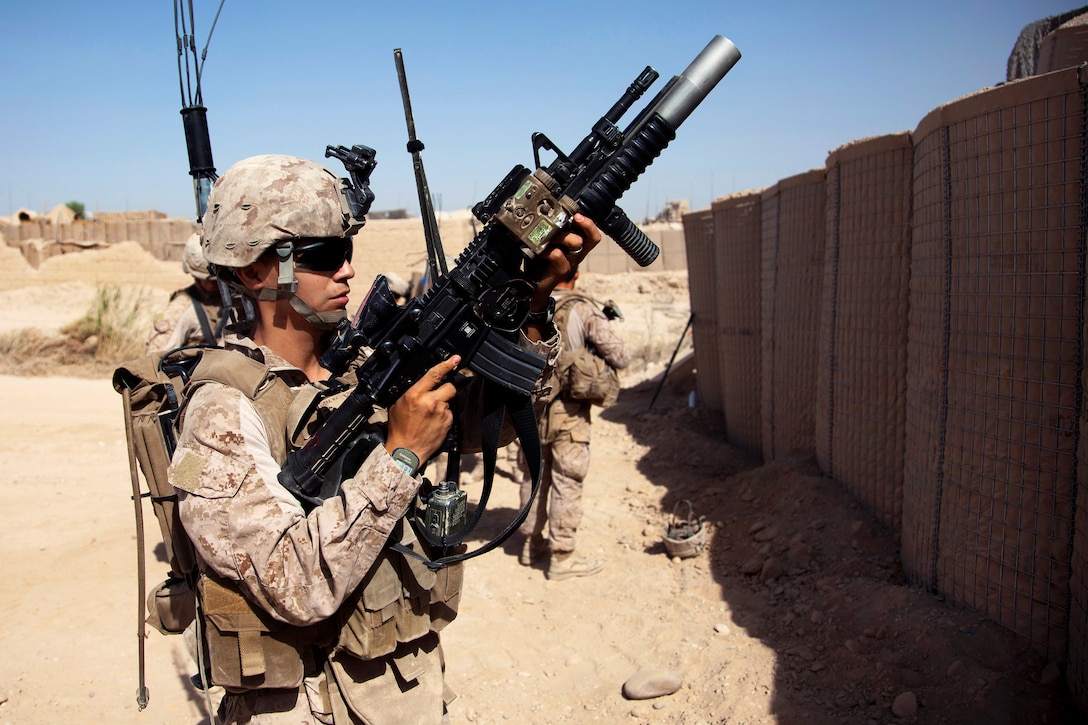 U.S. Marine Corps Cpl. Mykel Luera loads a 40mm grenade into his M203 ...