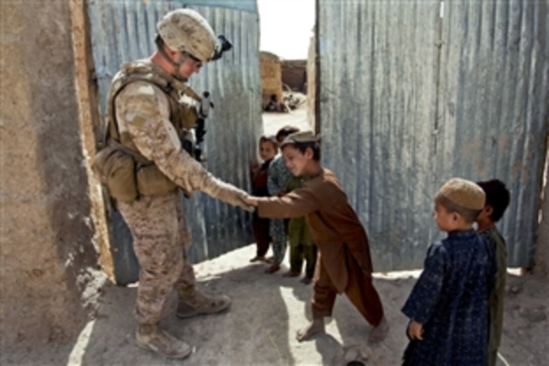U.S. Marine Corps Cpl. Patrick McCall, left, receives a high five from an Afghan boy during a security patrol in the Sangin district in Afghanistan's Helmand province, Sept. 6, 2012. McCall is a rifleman assigned to Bravo Company, 1st Battalion, 7th Marine Regiment, Regimental Combat Team 6.
