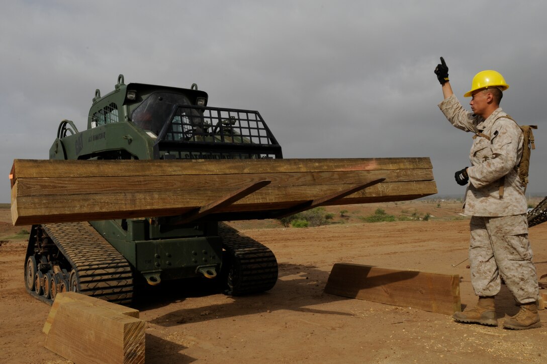 U.S. Marine Cpl. Hooiquoc Nguyen directs Lance Cpl. Michael Busman, both combat engineers with the Marine Wing Support Squadron 473, forward with a stack of beams a watchtower in Thies, Senegal, July 11, 2012. Loomis is participating in Western Accord 2012, a multi-lateral exercise with Senegalese, several Western African nations and the Armed Forces of Burkina Faso, Guinea, Gambia and France.