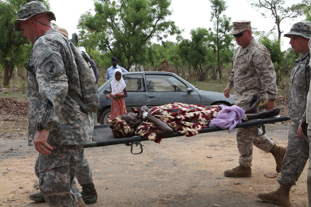 U.S. service members carry a local woman unable to walk into the gates of the clinic in Thies, Senegal, July 11. The medical care provided by the U.S. is part of Exercise Western Accord 2012. U.S. service members, primarily Reservists from the Marines, Army, Navy, and Air Force are taking part in Western Accord -- a multi-lateral exercise with Senegalese and several Western African nations. The training exercise runs from June 26 - July 24 and involves Armed Forces of Senegal, Burkina Faso, Guinea, Gambia and France.