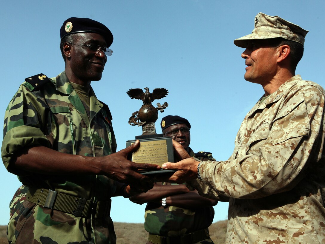 Colonel Douglas Fairfeld, Chief of Staff for U.S. Marine Corps Forces Africa, presents Senegalese Admiral Ousmane Ibrahima Sall, Deputy Chief of Staff of the Armed Forces of Senegal, a gift for being the host country for Exercise Western Accord 2012. Distinguished visitors included: Gen. Carter F. Ham, the commander of U.S. Africa Command; Lt. Col. Daniel Jones, U.S. Defense Attaché to Senegal; Col. Douglas Fairfeld, Chief of Staff for U.S. Marine Corps Forces Africa; The Honorable Robert Yamate, Charge d’Affairs of the U.S. Embassy in Dakar; Brig. Gen. Richard N. Harris Jr., Chief of Joint Staff of the Vermont Air National Guard; Admiral Ousmane, Ibrahima Sall, Deputy Chief of Staff of the Armed Forces of Senegal; Brig. Gen. Pape Samba Kamara, Chief of the Senegalese army; Brig. Gen. Gregoire Saint-Quentin, Commander, French Elements in Senegal; Col. Vinta Some, Burkina Faso Contingent Commander, ECOWAS Standby Force; Mr. Abdoulie Kah, Deputy Permanent Secretary of Ministry of Defense, Gambia; Brig. Gen. Namory Traore, Deputy Chief of Staff of the Armed Forces, Guinea. Exercise Western Accord 2012 is a multi-lateral training exercise with West African nations to increase understanding and interoperability, prevent conflict by enabling Africans to provide for their security and stability, strengthen relationships with partner nations, and promote and support U.S. national security priorities. Participating African nations include Senegal, Burkina Faso, Guinea, and Gambia.