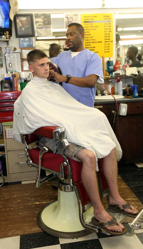 Darryl E. Leach, the owner of a local barber in Jacksonville, gives a haircut to Lance Cpl. Hayden Brown, a telephone systems and personal computer intermediate repairer with 2nd Intelligence Battalion at a barbershop in Jacksonville, N.C., Sept. 9. Leach greets service members with an infectious, upbeat and outgoing personality. After completing his active-duty service with the Navy he became a barber and worked in Philadelphia, but he returned to the crystal coast to serve those who serve in the military.