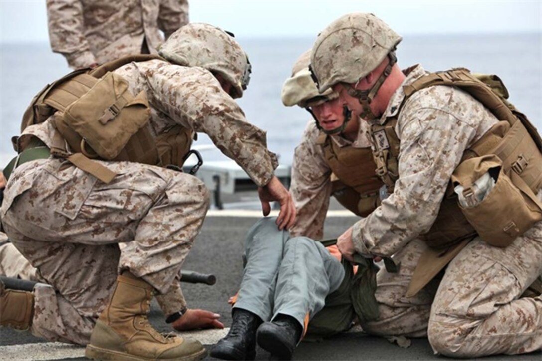 Marines from the 15th Marine Expeditionary Unit treat a simulated casualty during a Combat Life-saving Skills course aboard the USS Rushmore, Aug. 24. The four-day course teaches service members the basic level of Tactical Combat Casualty Care in order to stabilize casualties on the battlefield.