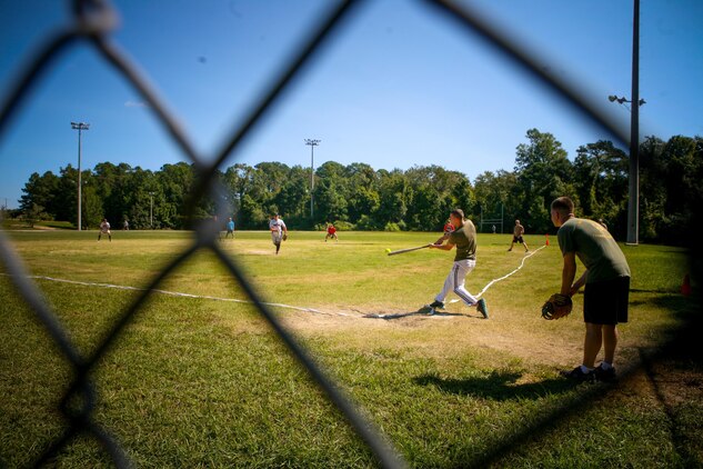 Marines and sailors with 2nd Battalion, 8th Marine Regiment, compete in a softball game as part of the 2/8 Olympics. The unit gave their weathered camouflage utilities a week-long break to carry out a battalion size Olympics promoting unit cohesion and competitive spirits.