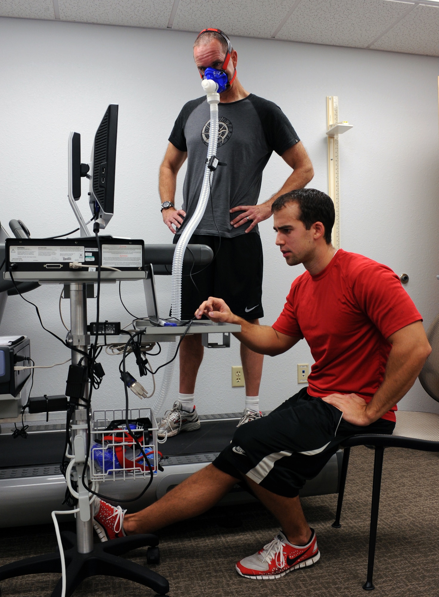 U.S. Air Force Lt. Col. John McArthur, 355th Medical Support Squadrons Radiology Flight chief, and David Friederich, Health and Wellness Center health and fitness specialist set up the metabolic cart prior to using the device at the HAWC on Davis-Monthan Air Force Base, Ariz., Sept. 11, 2012. The Metabolic cart measures your aerobic fitness. (U.S. Air Force photo by Airman 1st Class Christine Griffiths/Released) 