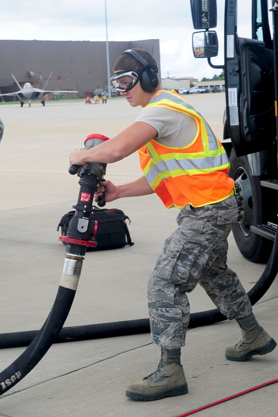 U.S. Air Force Airman 1st Class Jeremiah Garfoyle, 633rd Logistic Readiness Squadron refueling operator, prepares to attach a hose to an F-22 Raptor during a Hydrant Mobile Refueler procedure at Langley Air Force Base, Va., Sept. 13, 2012. After months of testing, this is the first time the HYMORE system has been used as a certified operation at Langley Air Force Base. (U.S. Air Force photo by Staff Sgt. Ashley Hawkins/Released)