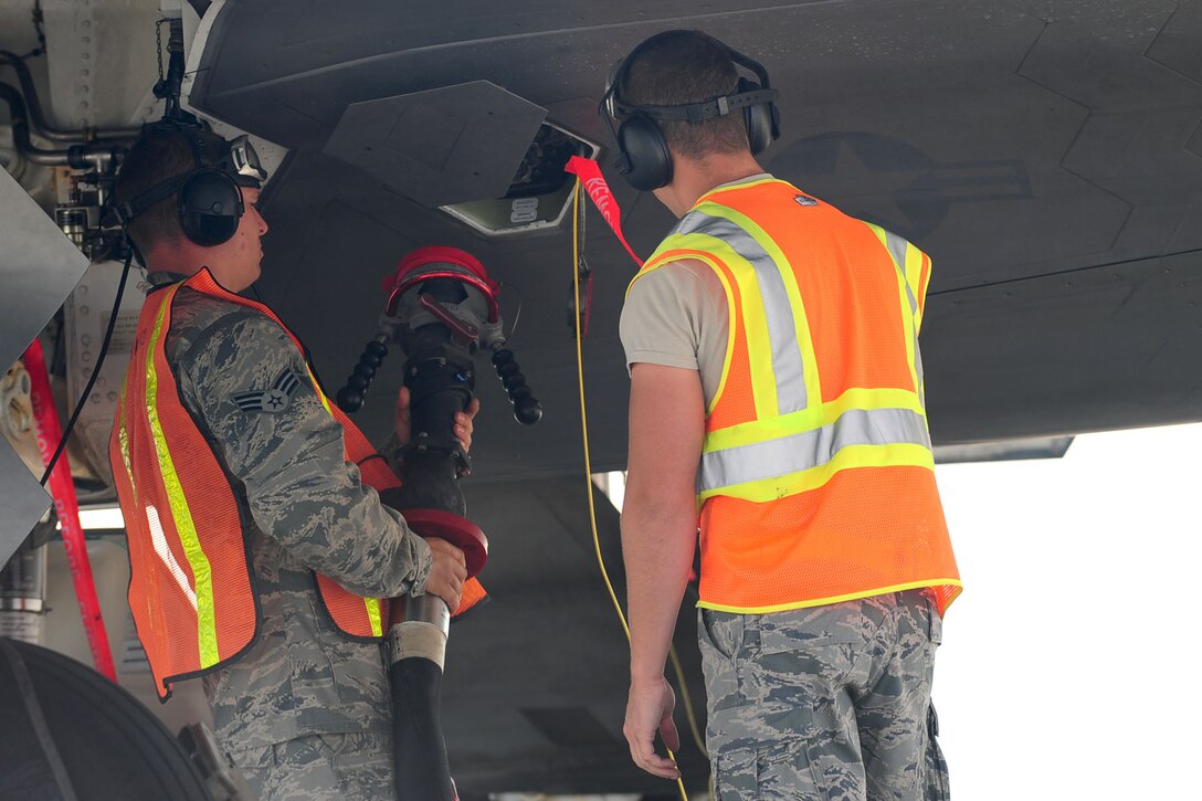 U.S. Air Force Senior Airman Timothy Deardorff, left, 1st Maintenance Squadron egress operator, and Airman 1st Class Jeremiah Garfoyle, 633rd Logistic Readiness Squadron refueling operator, attach a fuel hose to an F-22 Raptor during a Hydrant Mobile Refueler procedure at Langley Air Force Base, Va., Sept. 13, 2012. The new procedure, which could save the Air Force millions of dollars, saves time by allowing fuel to be pumped directly from a hydrant system instead of several R-11 fuel trucks. (U.S. Air Force photo by Staff Sgt. Ashley Hawkins/Released)