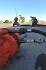 MINOT AIR FORCE BASE, N.D. -- Airman 1st Class Wilson Arocho and Senior Airman Sixto Trevino, 5th Civil Engineer Squadron water and fuel systems maintainers, pump water from a fuel tank here, Sept. 12. Keeping the water level down is a recurring maintenance job that keeps the fuel system running correctly. (U.S. Air Force photo/Senior Airman Brittany Y. Auld) 