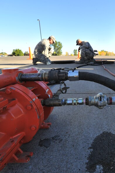 MINOT AIR FORCE BASE, N.D. -- Airman 1st Class Wilson Arocho and Senior Airman Sixto Trevino, 5th Civil Engineer Squadron water and fuel systems maintainers, pump water from a fuel tank here, Sept. 12. Keeping the water level down is a recurring maintenance job that keeps the fuel system running correctly. (U.S. Air Force photo/Senior Airman Brittany Y. Auld) 