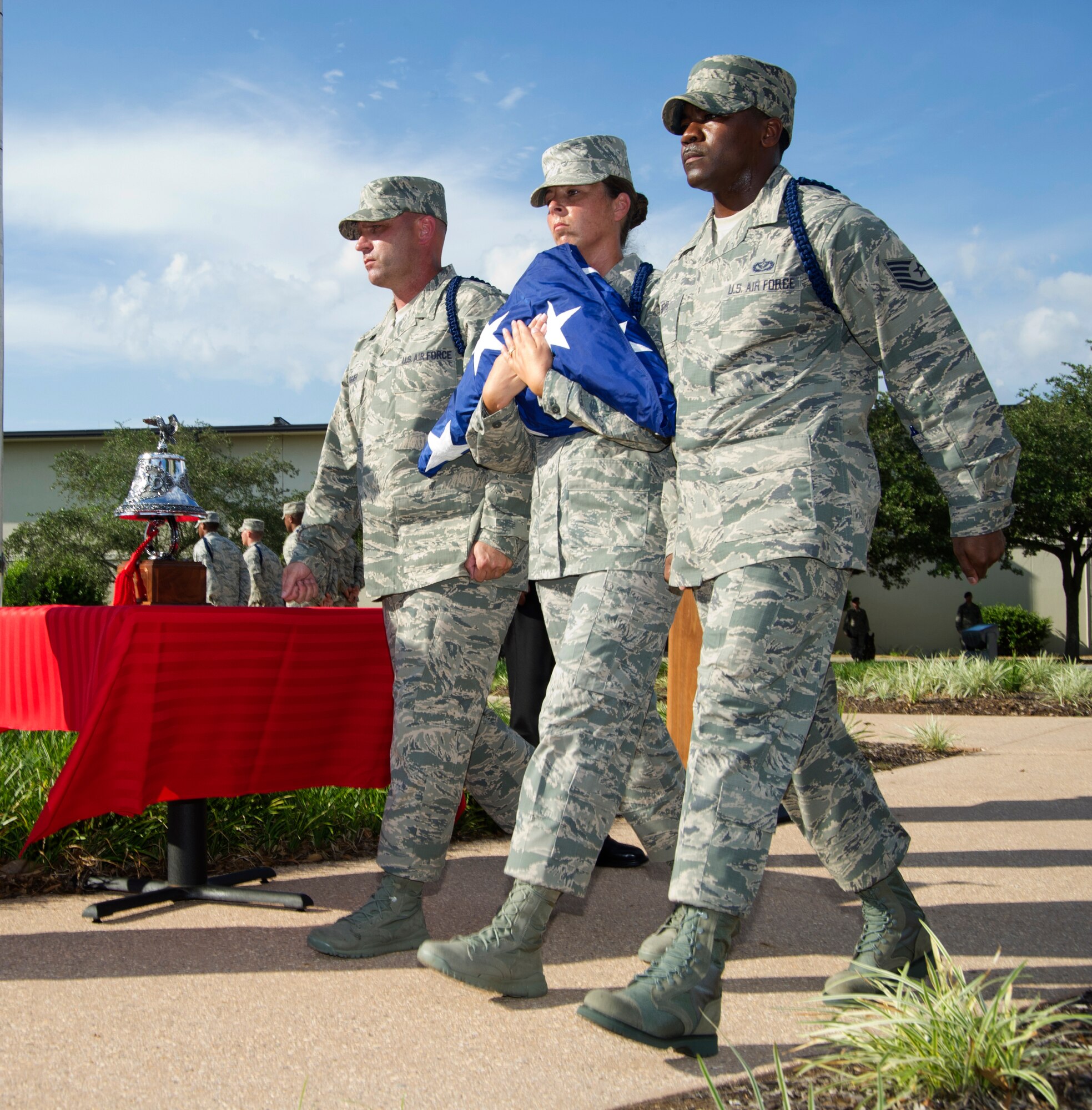 Senior Master Sgt. Anthony Fisher and Tech. Sgts. Julie Hammond and Terrance Boyd, 81st Training Group, complete a flag folding ceremony during a Sept. 11, 2012, retreat ceremony honoring those who lost their lives during the 9/11 attacks. The retreat ceremony took place in front of wing headquarters at Keesler Air Force Base, Miss. (U.S. Air Force photo by Adam Bond) 