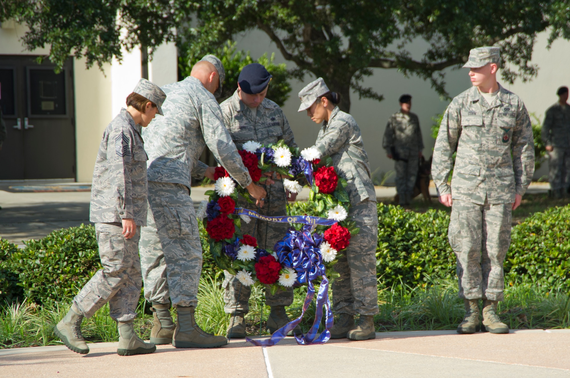 Chief Master Sgt. Angelica Johnson, 81st Training Wing command chief; Brig. Gen. Bradley Spacy, 81st TRW commander; Staff Sgt. Christopher Jarrell, 81st Security Forces Squadron; Maj. Melissa Dooley, 81st Medical Operations Squadron and Airman 1st Class Seth Corn, Keesler firefighter, assist in the placement of a wreath during a Sept. 11, 2012, retreat ceremony honoring those who lost their lives during the 9/11 attacks. The retreat ceremony took place in front of wing headquarters at Keesler Air Force Base, Miss.  (U.S. Air Force photo by Adam Bond)