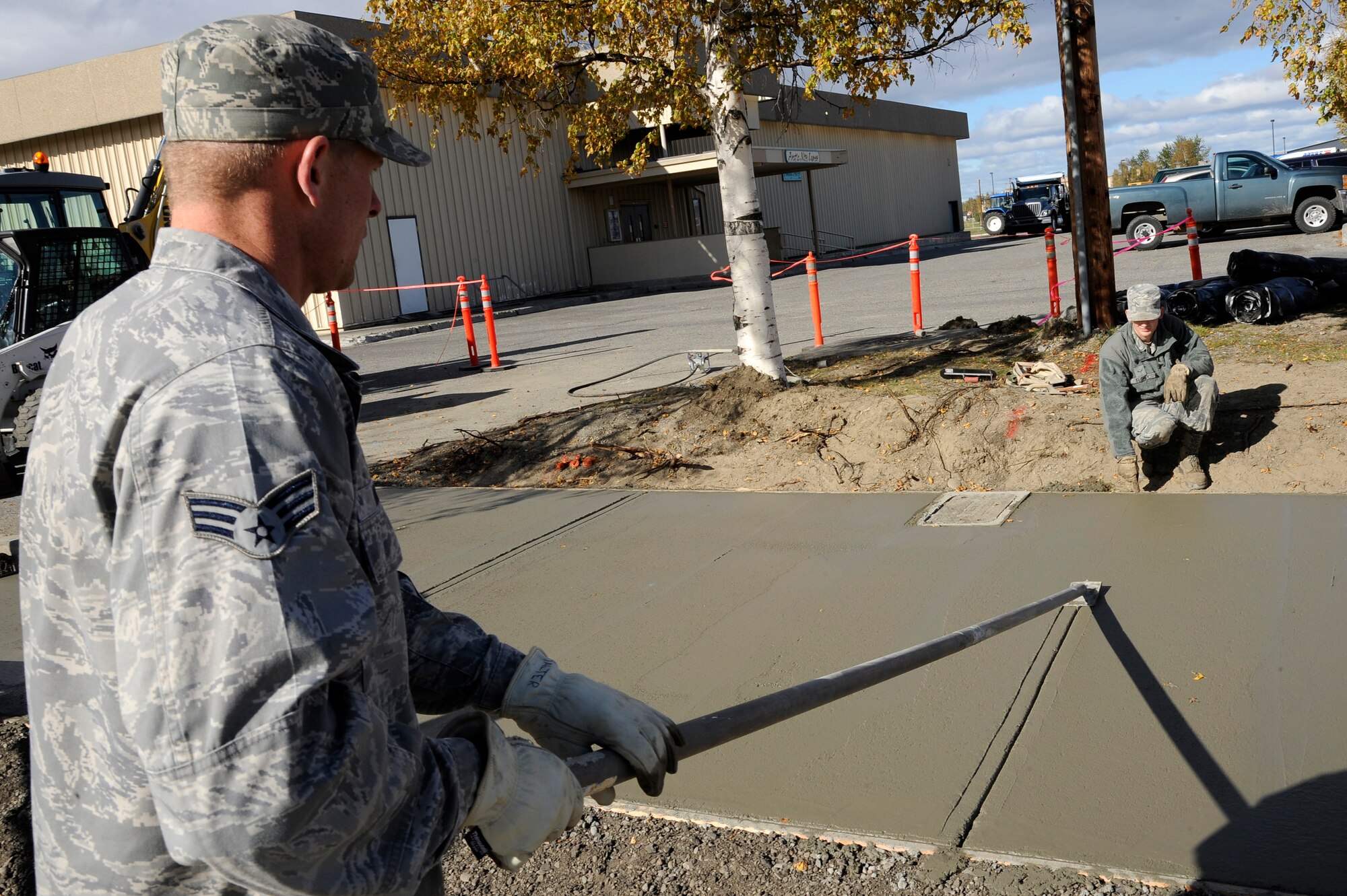 U.S. Air Force Senior Airman Ryan Halter and Airman 1st Class Richard Florey, 354th Civil Engineer Squadron pavement equipment operators, create joints on wet concrete Sept. 10, 2012, Eielson Air Force Base, Alaska.  The joints allow concrete to expand and shrink freely without cracks during Alaska’s severe weather changes. (U.S. Air Force photo/ Staff Sgt. Jim Araos)