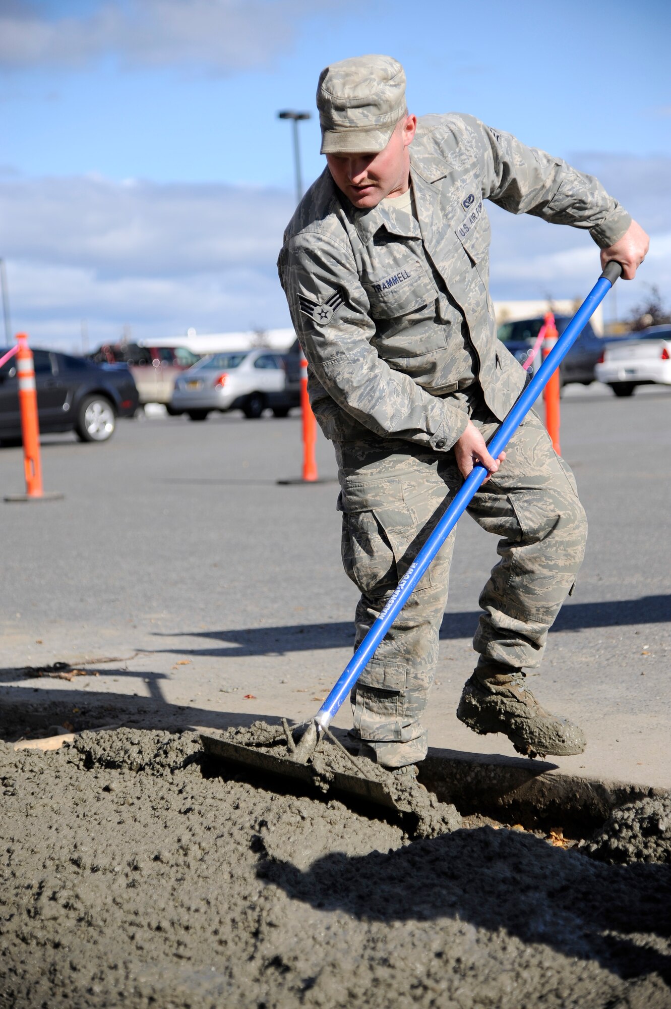 U.S. Air Force Senior Airman Justin Trammell, 354th Civil Engineer Squadron pavement equipment operator, uses a spreader to level concrete Sept. 10, 2012, Eielson Air Force Base, Alaska.  Once completed, the concrete will form a sidewalk for pedestrians to travel safely during the winter months. (U.S. Air Force photo/Staff Sgt. Jim Araos)