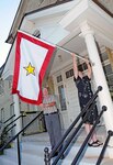 Jim Stokes and Marlene Nash, two of the Joint Base San Antonio-Fort Sam Houston
Survivor Outreach Services coordinators, affix the Gold Star flag Sept. 11 to the front
of the new SOS building. The building officially opens to the public Sept. 29 following the ribbon-cutting ceremony in honor of Gold Star Mothers’ and Families’ Day. (Photo by Sgt. Lee Ezzell,ARNORTH Public Affaris)