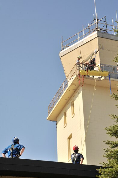 MINOT AIR FORCE BASE, N.D. -- Senior Airman Reginald Bramlett, firefighter for Barksdale Air Force Base, La.’s, 2nd Civil Engineering Squadron, Tech Sgt. David Hagenbuch, 312th Training Squadron instructor and Senior Airman Andrew Fruehan, of the 5th Civil Engineering Squadron, lower a mock victim down to safety during high angle rescue training exercise here, Aug. 20. Rescue Technician Instructors Staff Sgt. Aaron Brackett and Tech Sgt. David Hagenbuch from the Louis F. Garland Department of Defense Fire Academy at Goodfellow Air Force Base, Texas, came to Minot AFB as part of the Mobile Training Team. The MTT goes from base to base offering training that is conducted year round at the Fire Academy. (U.S. Air Force photo/Senior Airman Brittany Y. Auld)
