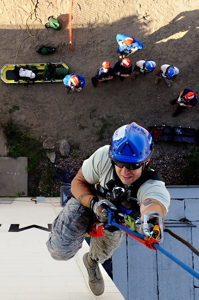 MINOT AIR FORCE BASE, N.D. - Senior Airman Andrew Fruehan, 5th Civil Engineering Squadron firefighter, ascends to the top of the air traffic control tower during a high angle rescue training exercise here, Aug. 20. Instructors from the Louis F. Garland Department of Defense Fire Academy at Goodfellow Air Force Base, Texas, came to Minot AFB as part of a Mobile Training Team and taught Airmen firefighters here, including others from distinct bases, low and high angle rescue procedures. Airmen were also taught rappelling, which included passing a knot in the line, properly ascending up and down ropes, patient pick-off rescues, and confined space rescues. (U.S. Air Force photo/Senior Airman Jesse Lopez)