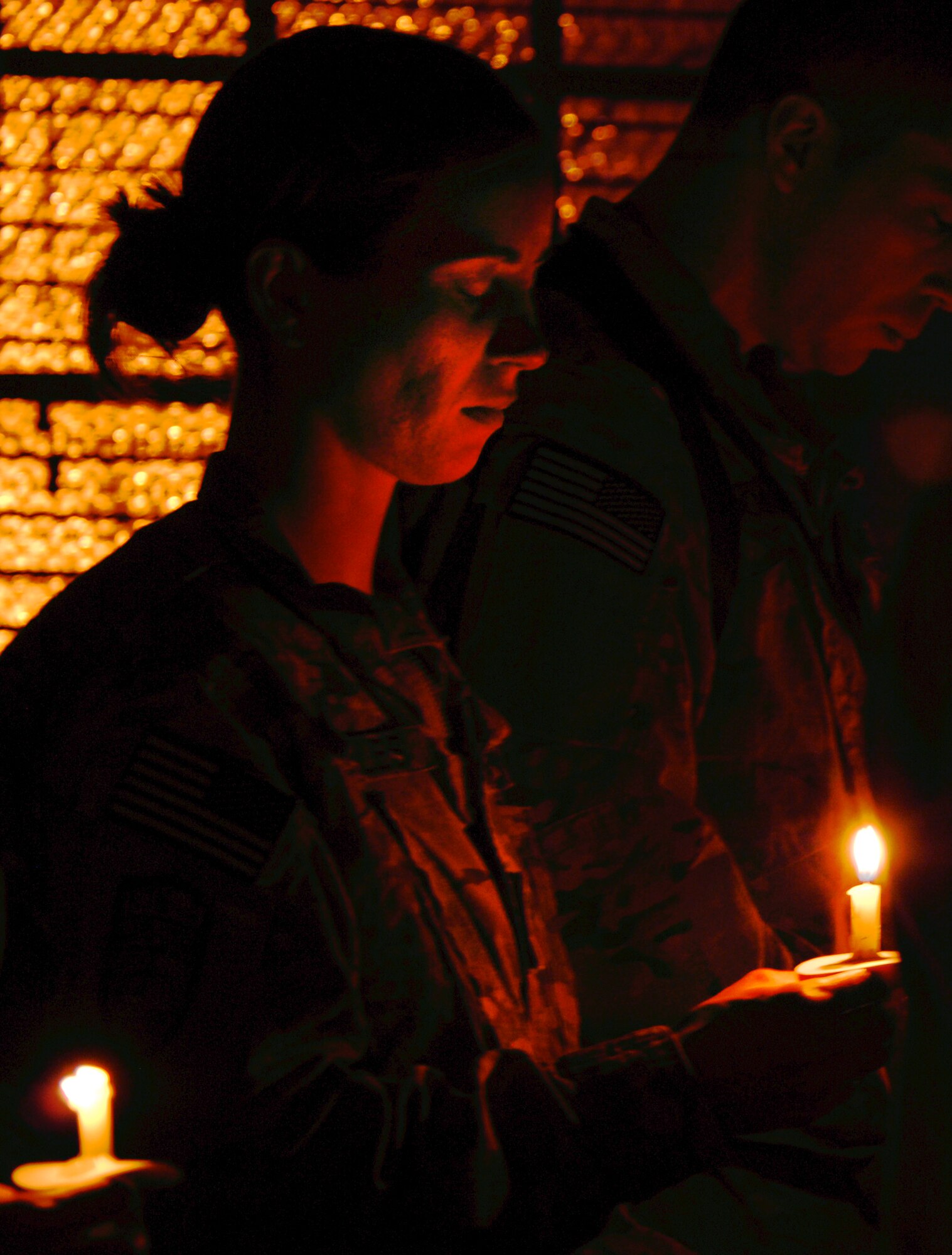 U.S. military members and civilians read names of those who perished during the September 11, 2001, terrorist attacks by candlelight during a “9/11” memorial observance at Bagram Airfield, Afghanistan, Sept. 11, 2012. Portions of the observance, called “9/11 in Memoriam,” included songs written by Bill Monaghan, a singer/song writer who lost his brother in 2010 during a U.S. Navy training accident. (U.S. Air Force photo/SSgt Jeff Nevison)