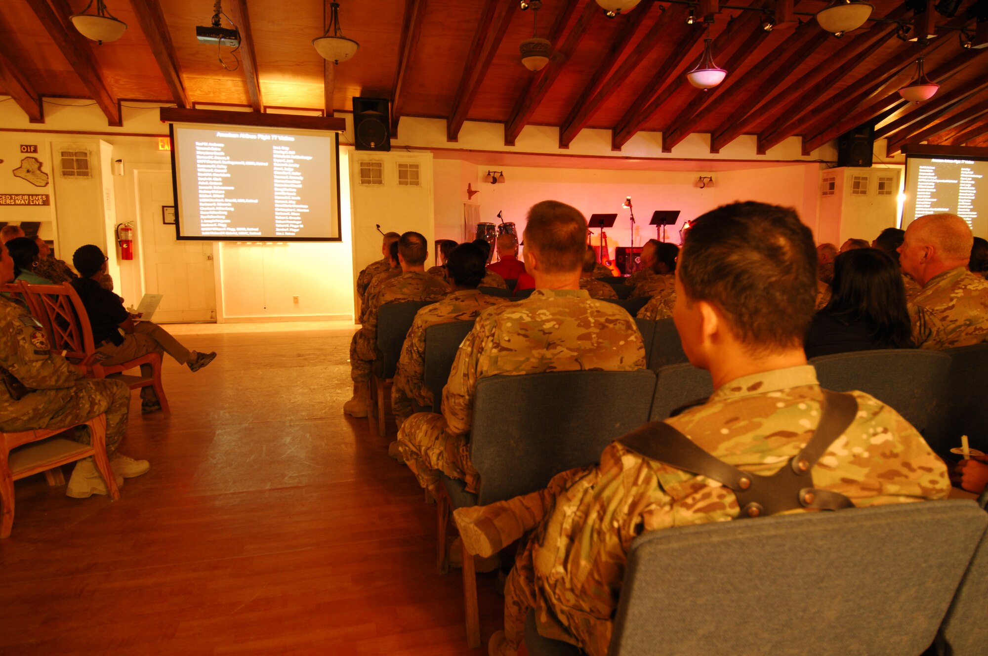 U.S. military members and civilians read names of those who perished during the September 11, 2001, terrorist attacks by candlelight during a “9/11” memorial observance at Bagram Airfield, Afghanistan, Sept. 11, 2012. Portions of the observance, called “9/11 in Memoriam,” included songs written by Bill Monaghan, a singer/song writer who lost his brother in 2010 during a U.S. Navy training accident. (U.S. Air Force photo/SSgt Jeff Nevison)