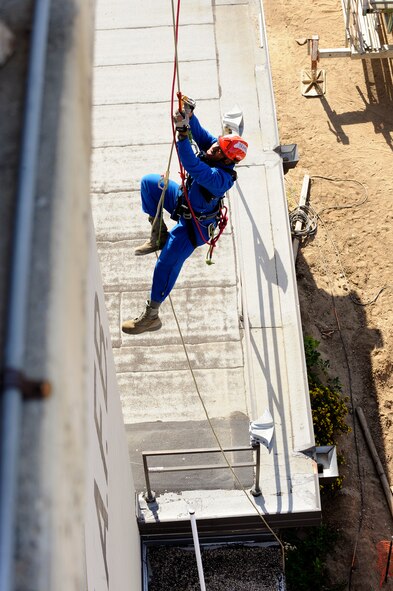 MINOT AIR FORCE BASE, N.D. – Senior Airman Reginald Bramlett, 5th Civil Engineering Squadron firefighter, ascends to the top of the air traffic control tower during a high angle rescue training exercise here, Aug. 20. Instructors from the Louis F. Garland Department of Defense Fire Academy at Goodfellow Air Force Base, Texas, came to Minot AFB as part of the Mobile Training Team taught Minot Airmen low and high angle rescue procedures as well as rappelling including passing a knot in the line, patient pick off rescues, and confined space rescues base helping to keep Minot fire fighters sharp in their capabilities to save lives in the face of danger.  (U.S. Air Force photo/Senior Airman Jesse Lopez)