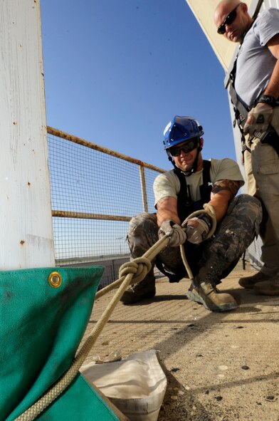 MINOT AIR FORCE BASE, N.D. – Senior Airman Andrew Fruehan, 5th Civil Engineering Squadron firefighter, secures a his rope at the top of the air traffic control tower during a high angle rescue training exercise here, Aug. 20. Instructors from the Louis F. Garland Department of Defense Fire Academy at Goodfellow Air Force Base, Texas, came to Minot AFB as part of the Mobile Training Team taught Minot Airmen low and high angle rescue procedures as well as rappelling including passing a knot in the line, patient pick off rescues, and confined space rescues base helping to keep Minot fire fighters sharp in their capabilities to save lives in the face of danger.  (U.S. Air Force photo/Senior Airman Jesse Lopez)