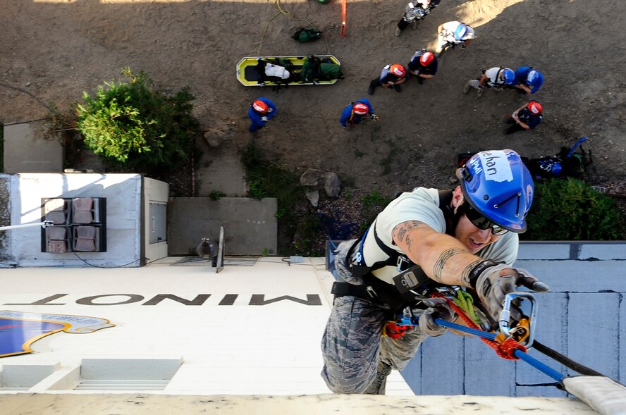 MINOT AIR FORCE BASE, N.D. – Senior Airman Andrew Fruehan, 5th Civil Engineering Squadron firefighter, ascends to the top of the air traffic control tower during a high angle rescue training exercise here, Aug. 20. Instructors from the Louis F. Garland Department of Defense Fire Academy at Goodfellow Air Force Base, Texas, came to Minot AFB as part of the Mobile Training Team taught Minot Airmen low and high angle rescue procedures as well as rappelling including passing a knot in the line, patient pick off rescues, and confined space rescues base helping to keep Minot fire fighters sharp in their capabilities to save lives in the face of danger.  (U.S. Air Force photo/Senior Airman Jesse Lopez)