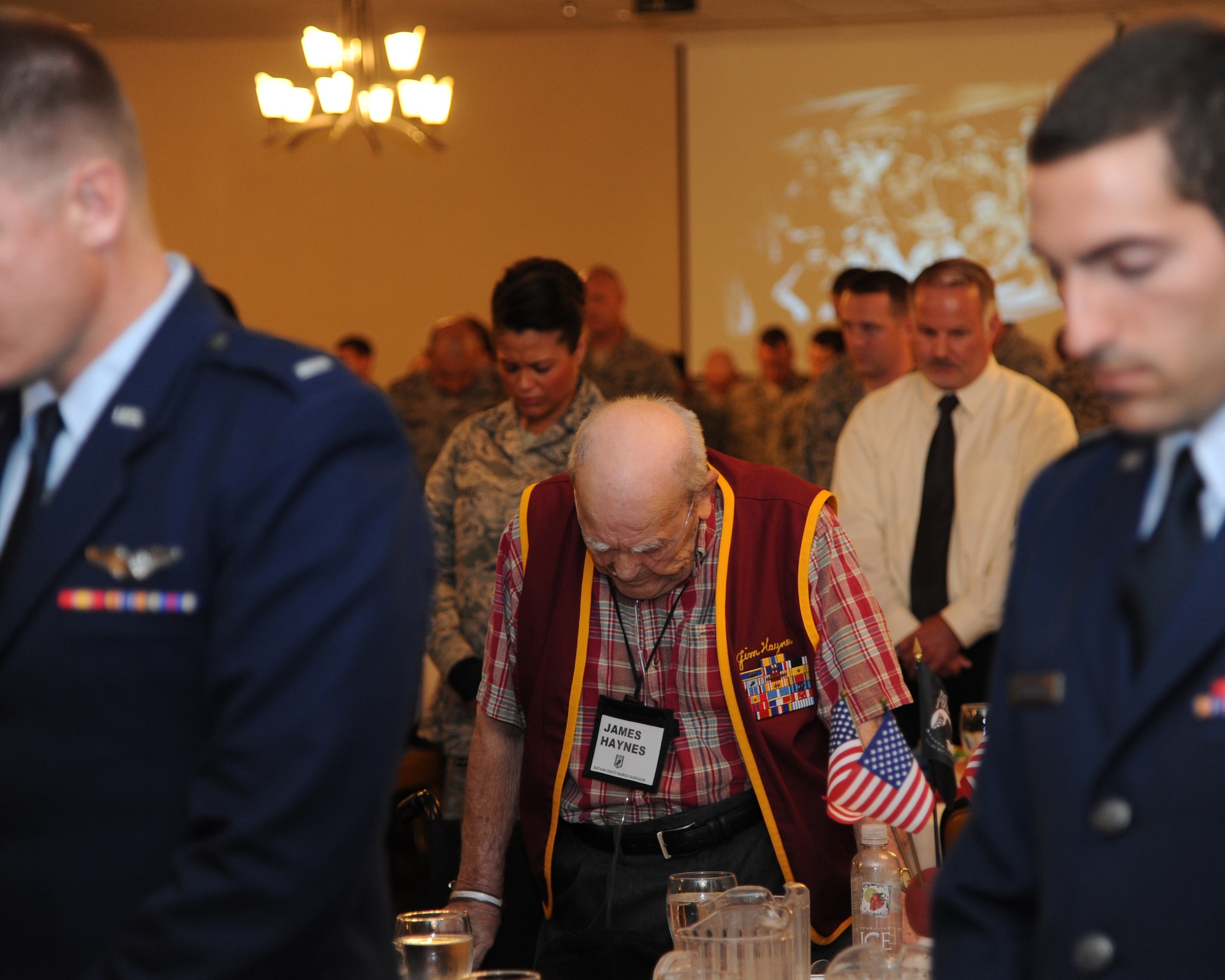 Bataan Death March survivor Master Sgt. James Haynes, U.S. Army Air Force, bows his head during the invocation at the 70th Anniversary luncheon held on Barksdale Air Force Base, La., Sept. 4 in honor of the time Haynes and four other veterans spent as prisoners of war during World War II. This day was significant because it also marked the 67th Anniversary of over 2,000 Japanese soldiers surrendering on Wake Island two days after the formal surrender of Japan. (U.S. Air Force photo/Airman 1st Class Joseph A. Pagán Jr.)(RELEASED)