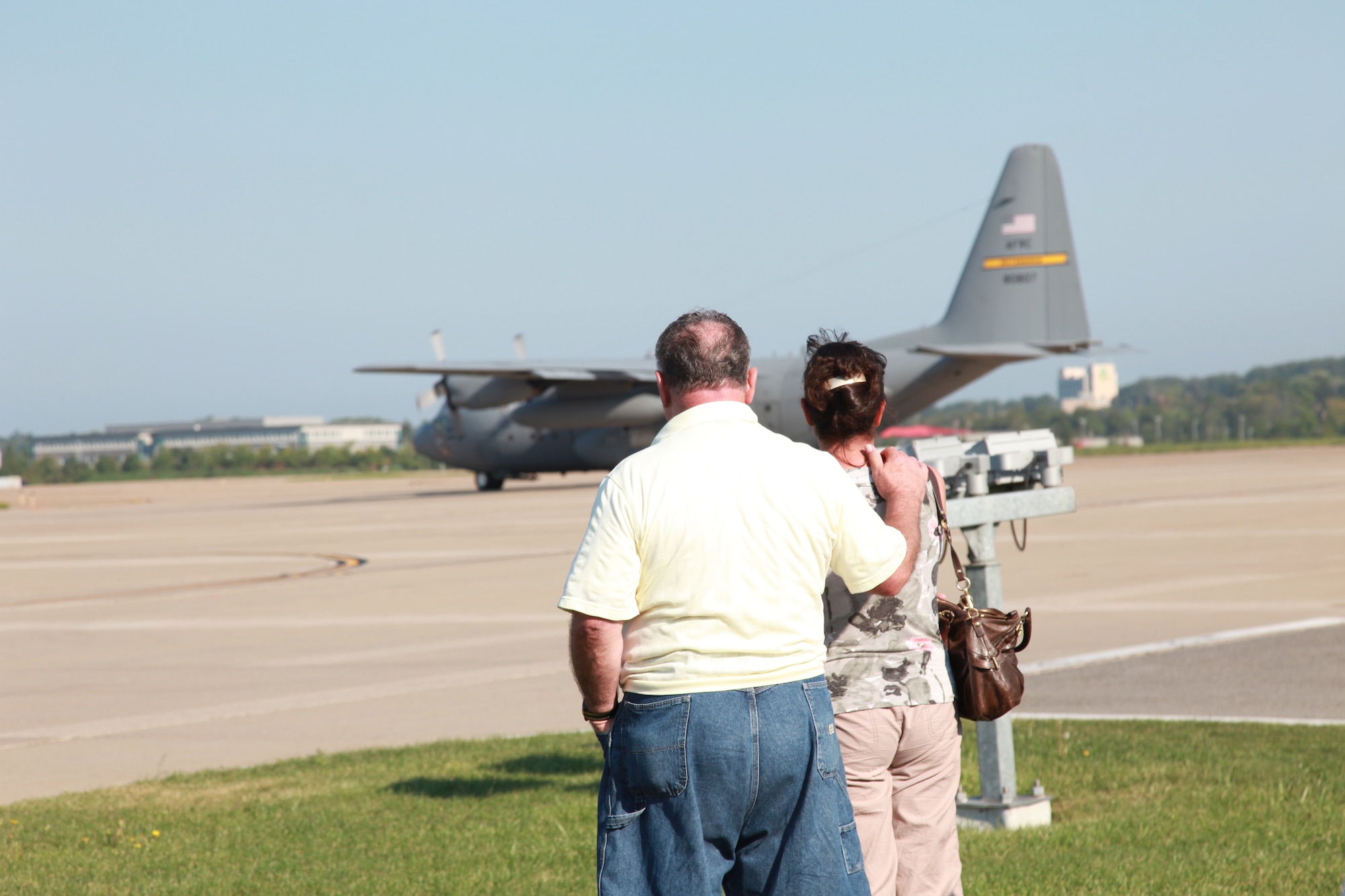 Family members of deploying 911th Airlift Wing Airmen look on ward as a C-130 Hercules has finished being loaded with cargo, crew and maintenance personnel Sept. 6, 2012. The deployment will support an Air Expeditionary Force rotation delivering supplies and equipment in and out of areas such as the Persian Gulf, Afghanistan and Horn of Africa. (U.S. Air Force photo by Tech. Sgt. Ralph Van Houtem/Released)