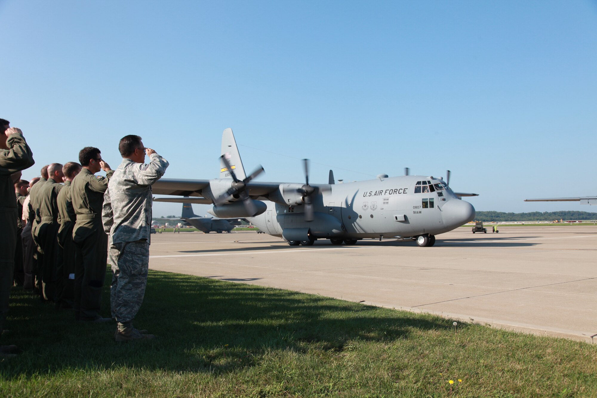 Members of the 911th Airlift Wing salute a passing C-130 Hercules carrying fellow Airmen leaving for a four-month deployment in support of an Air Expeditionary Force rotation Sept. 6, 2012. During the deployment, maintenance and operations personnel as well as several of the units C-130 aircraft will be tasked with delivering supplies and equipment overseas. (U.S. Air Force photo by Tech. Sgt. Ralph Van Houtem/Released)