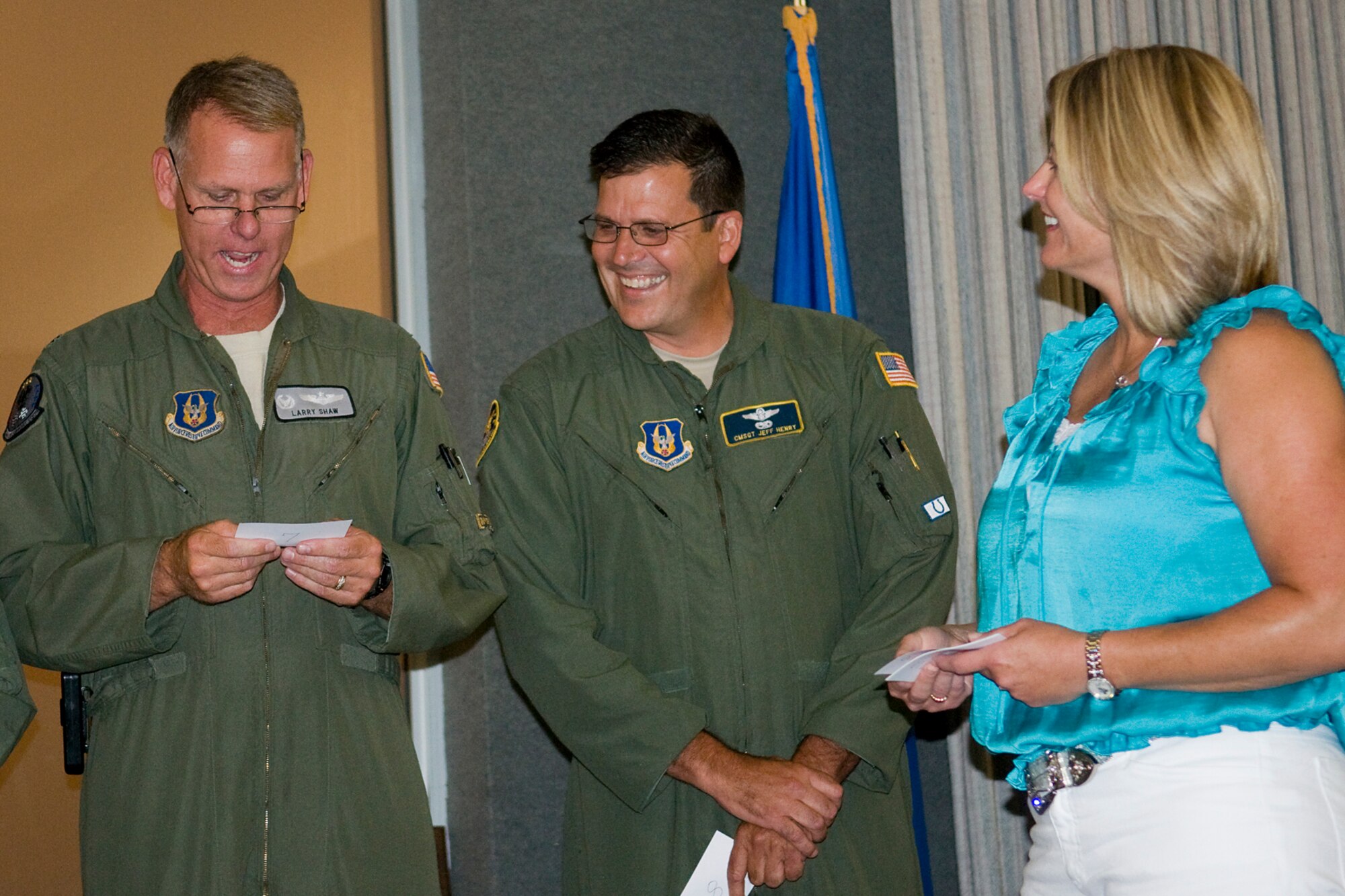 GRISSOM AIR RESERVE BASE, Ind. -- Lt. Col. Larry Shaw, left, reads a note card given to him by Lisa Wietbrock, wife of newly promoted Col. Paul Wietbrock, as Chief Master Sgt. Jeff Henry looks on during Colonel Wietbrock's pin-on ceremony here Aug. 25. Colonel Wietbrock had his wife hand out several of the note cards to fellow servicemembers as a way to remember their service together at Grissom. (U.S. Air Force photo/Tech. Sgt. Mark Orders-Woempner)
