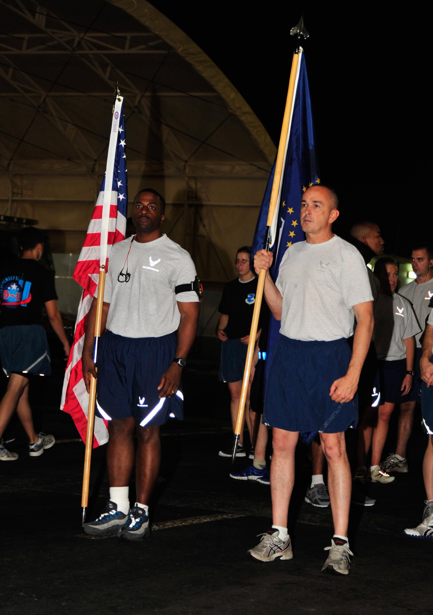 SOUTHWEST ASIA - U.S. Air Force Senior Master Sgts. Christopher Hurst, 380th Expeditionary Security Forces Squadron, and Marvin Wagoner, 380th Expeditionary Civil Engineer Squadron, carry the American and 9/11 memorial flags to begin a 9/11 Memorial 5-kilometer Walk to Remember Sept. 11, 2012. The wing honored the memory of the events of 9/11 with a 5-kilometer walk/run and 12-hour walk that began and ended at the wing's 9/11 memorial site. (U.S. Air Force photo/Tech. Sgt. Joshua Leach)