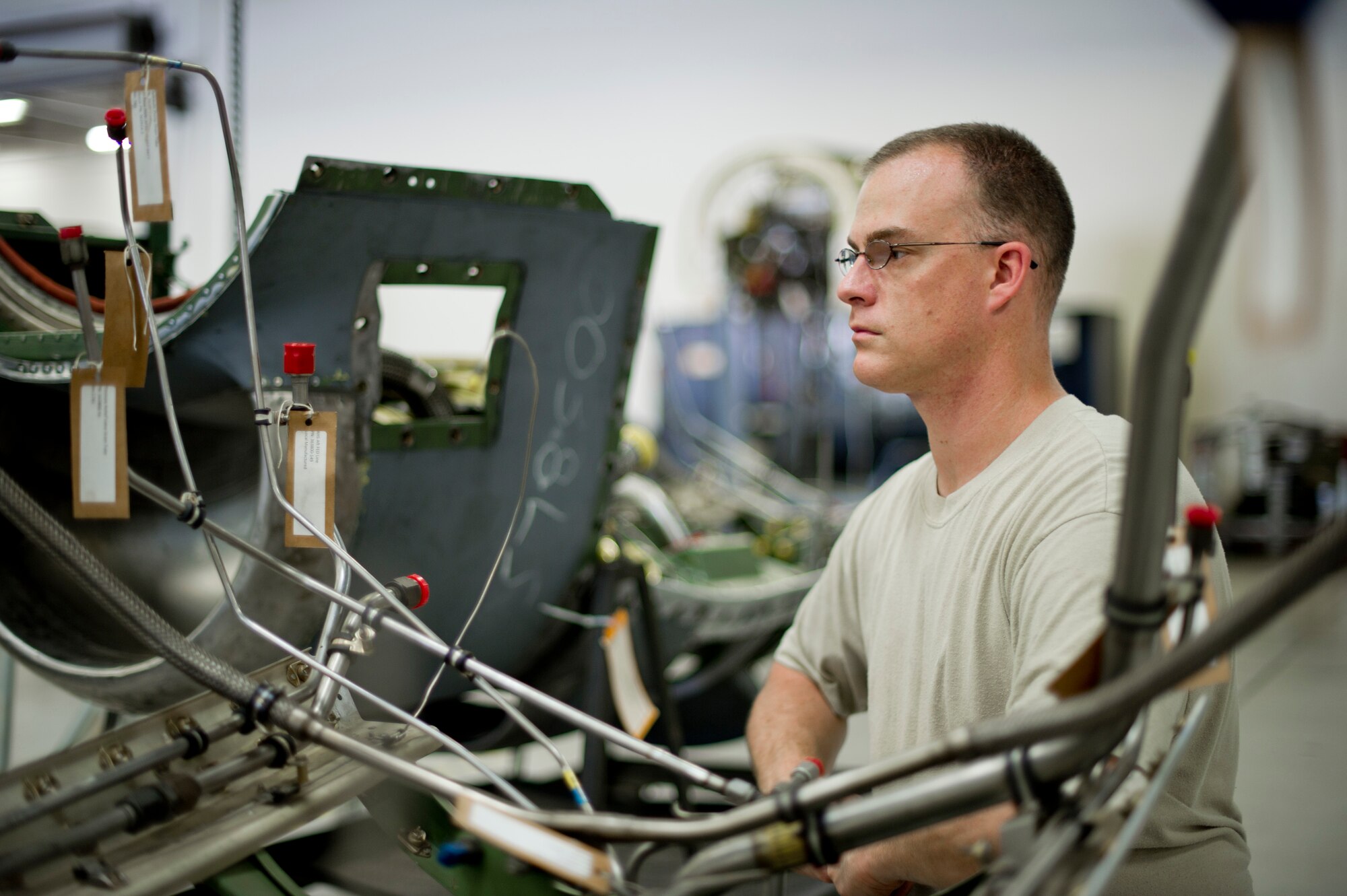 YOKOTA AIR BASE, Japan – Technical Sgt. Michael Kimionakis, 374th Maintenance Squadron propulsion flight aerospace propulsion craftsman, installs fire detection lines and drain lines at Yokota Air Base, Japan, Sept. 11, 2012. Ensuring the lines are installed correctly is important because this prevents chafing on the tubes, which would cause them to malfunction. (U.S. Photo by Staff Sgt. Stacy Moless)