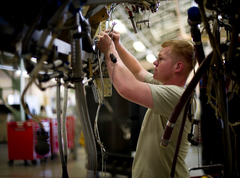 YOKOTA AIR BASE, Japan -- Airman 1st Class Nicholas Henderson, 374th Maintanance Squadron propulsion flight aerospace propulsion apprentice, installs an oil tank bracket on a C-130 Hercules at Yokota Air Base, Japan on Sept. 11, 2012. Installing the tank is just one of the steps required during scheduled maintenance on the C-130 engine. (U.S. Photo by Staff Sgt. Stacy Moless)