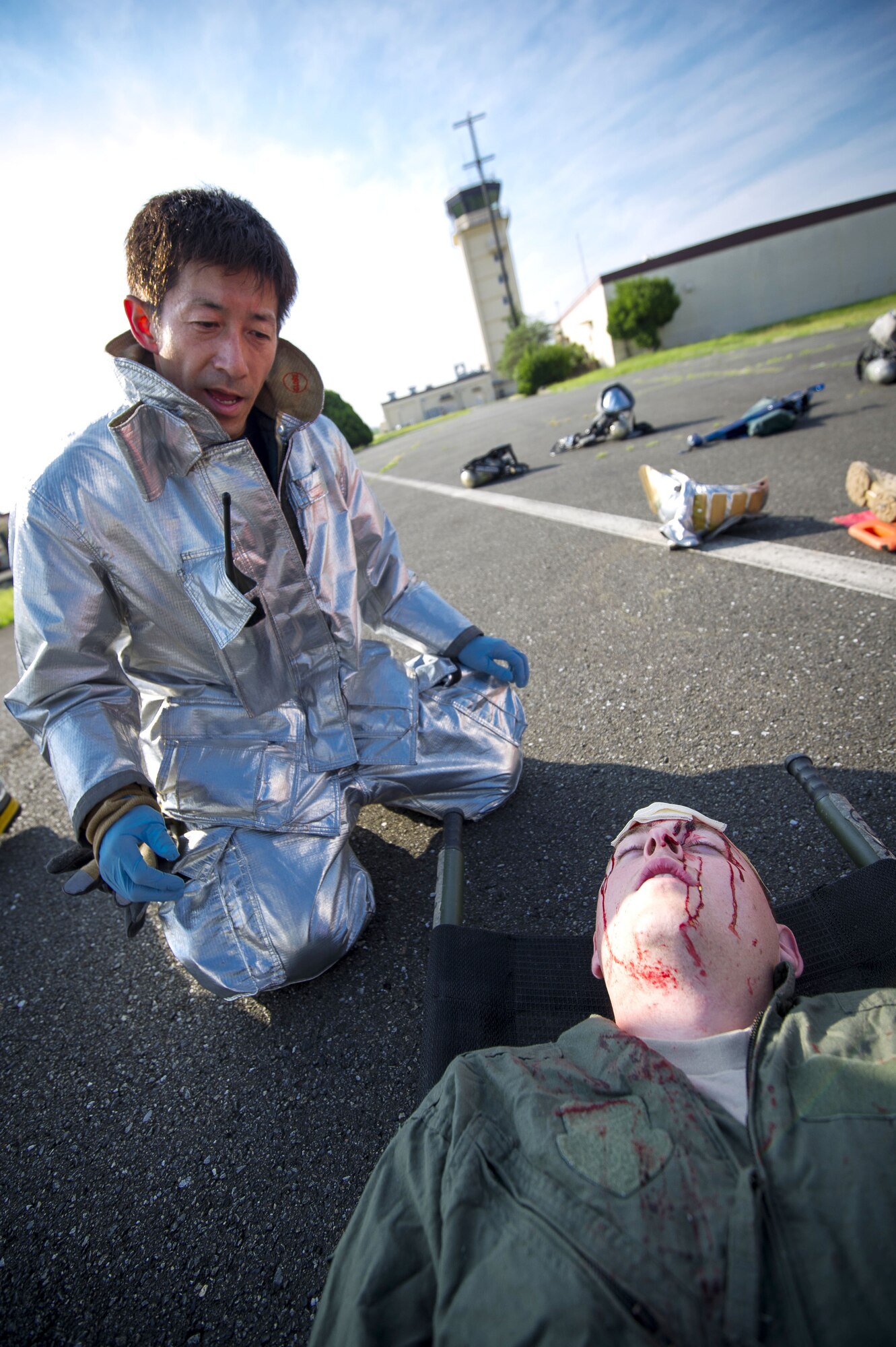YOKOTA AIR BASE, Japan – Kasuya Kazuyuki, 374th Civil Engineer Squadron firefighter crew chief, assists a simulated victim during an emergency management exercise at Yokota Air Base, Japan on Sept. 13, 2012. During the scenario, firefighters aided victims after a C-130 Hercules crashed during landing. (U.S. Air Force photo by Staff Sgt. Chad C. Strohmeyer)