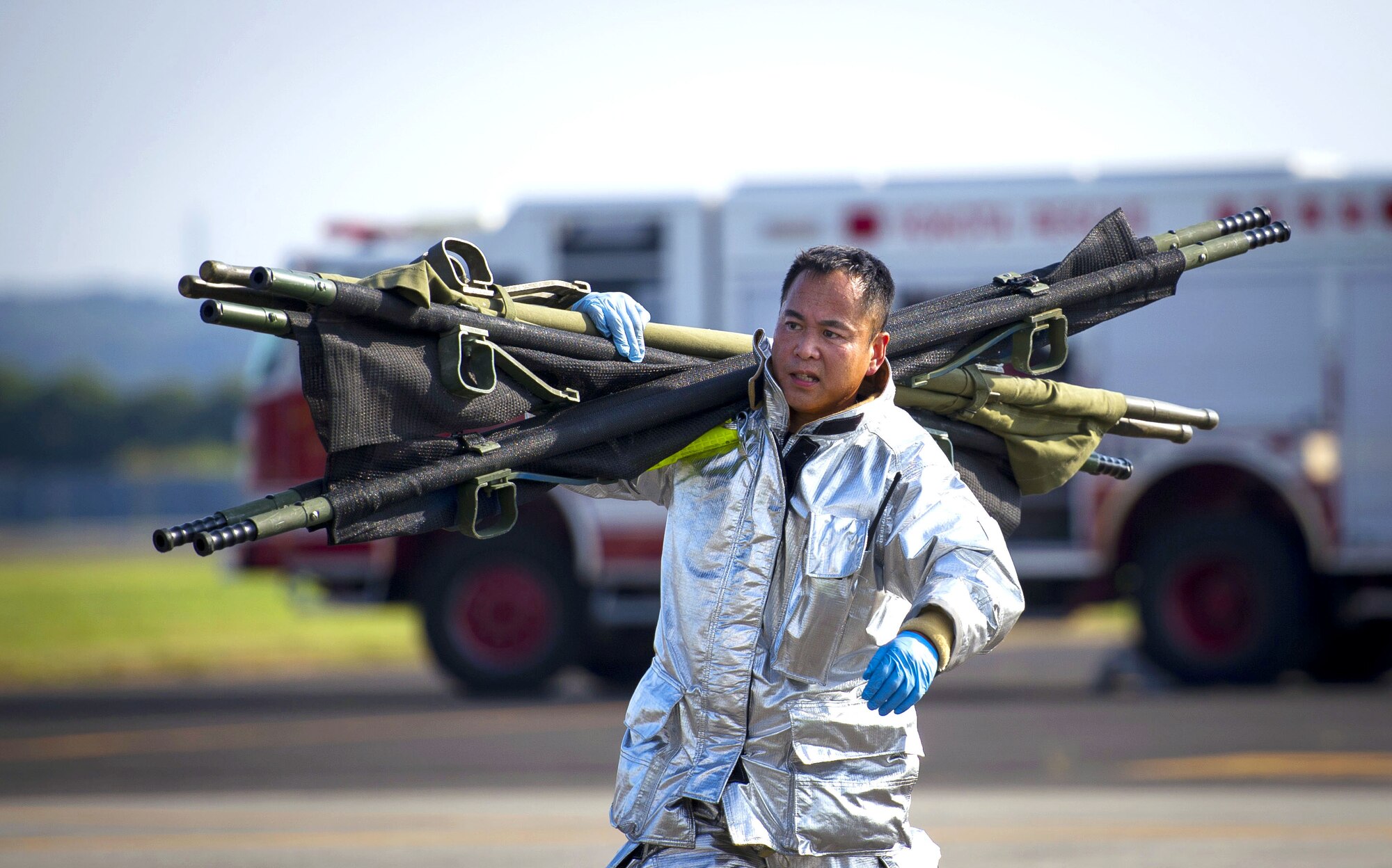 YOKOTA AIR BASE, Japan – Yoichi Sudo, 374th Civil Engineer Squadron firefighter, carries two litters to aid simulated victims during an emergency management exercise at Yokota Air Base, Japan on Sept. 13, 2012. During the scenario, firefighters aided victims after a C-130 Hercules crash-landed. (U.S. Air Force photo by Staff Sgt. Chad C. Strohmeyer)