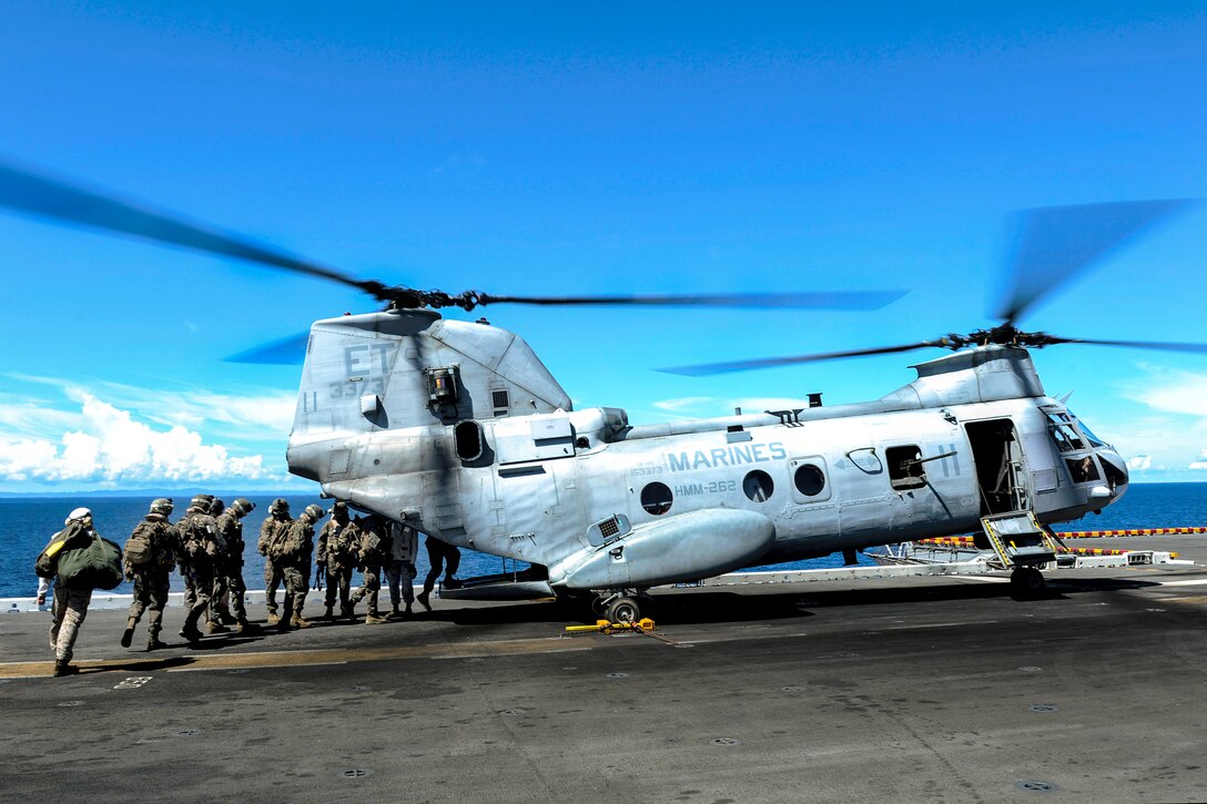 U.S. Marines board a CH-46 Sea Knight helicopter on the flight deck of the amphibious assault ship USS Bonhomme Richard under way in the Phillipine Sea, Sept. 2, 2012. The Marines are assigned to the 31st Marine Expeditionary Unit. The Bonhomme Richard is the lead ship of the only forward-deployed amphibious ready group. The helicopter is assigned to Marine Medium Helicopter Squadron 262.