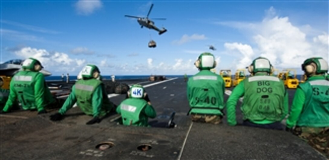 Logistics specialists stand by as an MH-60S Sea Hawk helicopter from Helicopter Sea Combat Squadron 8 delivers stores to the flight deck of the aircraft carrier USS John C. Stennis (CVN 74) during a vertical replenishment in the Pacific Ocean on Sept. 8, 2012.  The Nimitz-class aircraft carrier is returning to the U.S. 7th and 5th Fleet areas of responsibility four months ahead of schedule.  