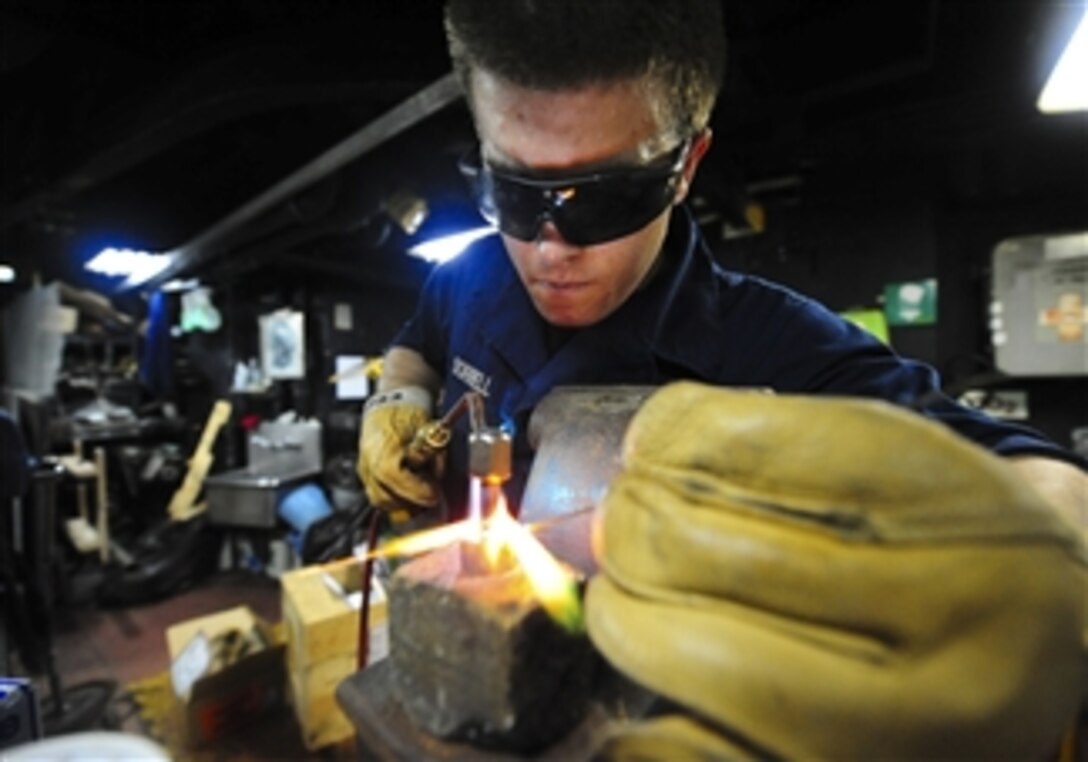 Fireman Nicolas Sorrell uses a torch to heat a copper pipe in the hull technician workshop of the amphibious dock landing ship USS Tortuga (LSD 46) on Sept. 7, 2012.  Tortuga is part of a forward-deployed amphibious ready group and is operating in the U.S. 7th Fleet area of operations.  