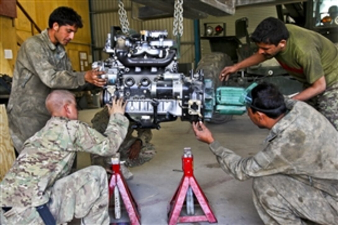 U.S. Army Pvt. Rodger Pendergrass and Afghan soldiers repair an engine at the motor pool on Forward Operating Base Airborne in Wardak province, Afghanistan, Sept. 4, 2012. Pendergrass is assigned to 4th Battalion, 319th Field Artillery Regiment, 173rd Airborne Brigade Combat Team.