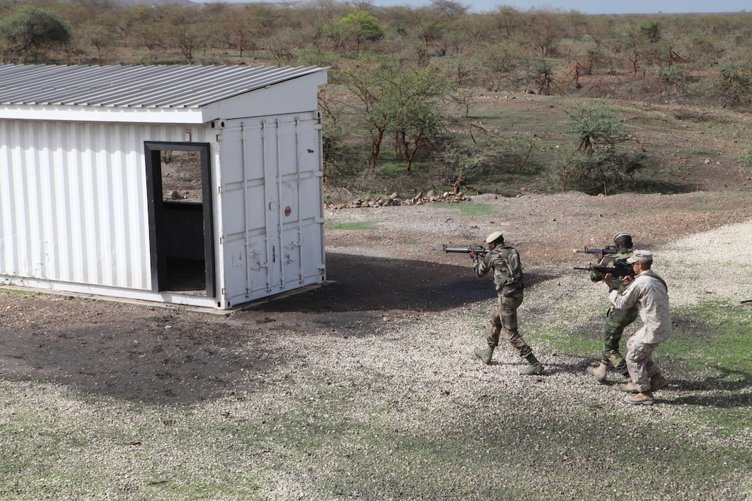 Cpl. Jason Dumke, a team leader with Weapons Company, 3rd Battalion 25th Marine Regiment, and two members of the Senegalese army move to clear a building during urban combat techniques training, July 13. U.S. service members, primarily Reservists from the Marines, Army, Navy, and Air Force are taking part in Western Accord -- a multi-lateral exercise with Senegalese and several Western African nations. The training exercise runs from June 26 - July 24 and involves Armed Forces of Senegal, Burkina Faso, Guinea, Gambia and France.
