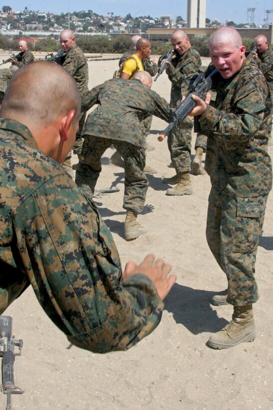 With a simulated M16-A4 service rifle, a recruit of Company G, 2nd Recruit Training Battalion, verbally tells his fellow recruit to get on the ground after he had just gotten him to release the rifle abaord Marine Corps Recruit Depot San Diego Sept. 6. Recruits are taught to control situations using the least amount of force. 