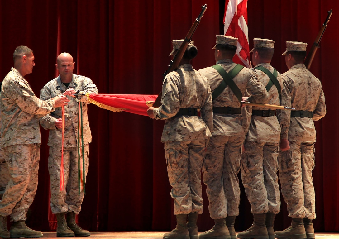Brig. Gen. George W. Smith, Combat Center Commanding General, and Sgt. Maj. Matthew Brookshire, Combat Center Sergeant Major, attach battle streamers onto the base's organizational colors during the commemoration of the 60th anniversary of the Combat Center Aug. 24.