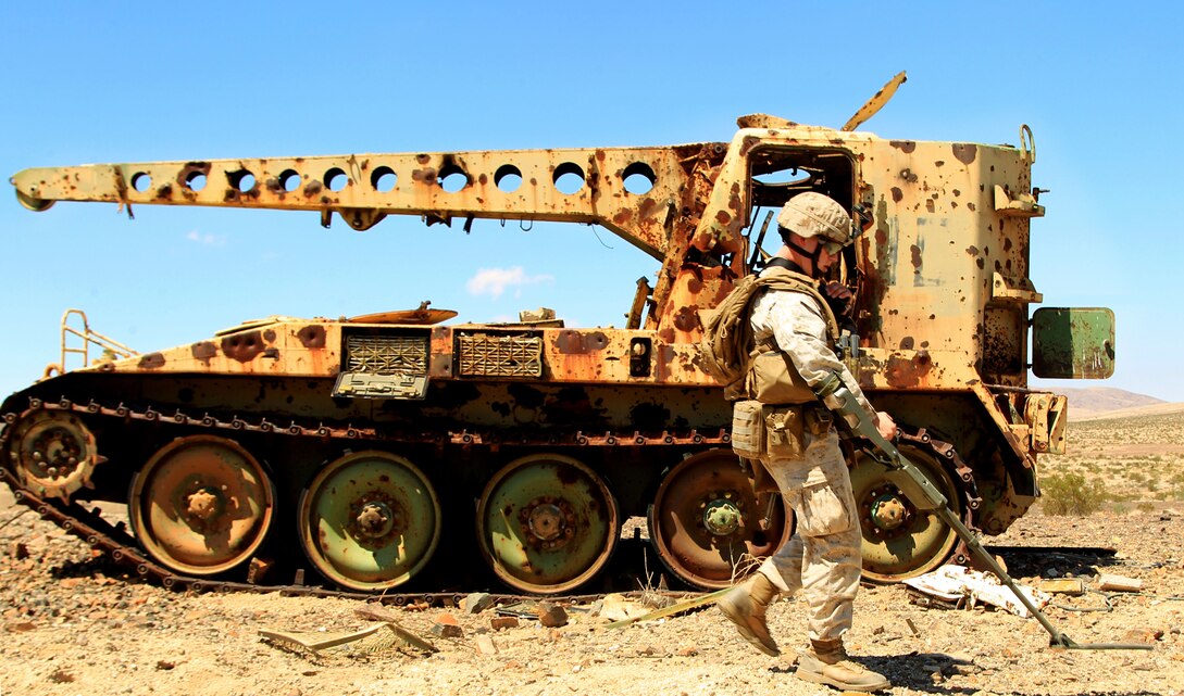 Cpl. Alex Naumovich, rifleman, 3rd Battalion, 4th Marine Regiment, sweeps through an improvised explosive device course filled with simulated IEDs Aug. 23 at the Noble Pass training area.