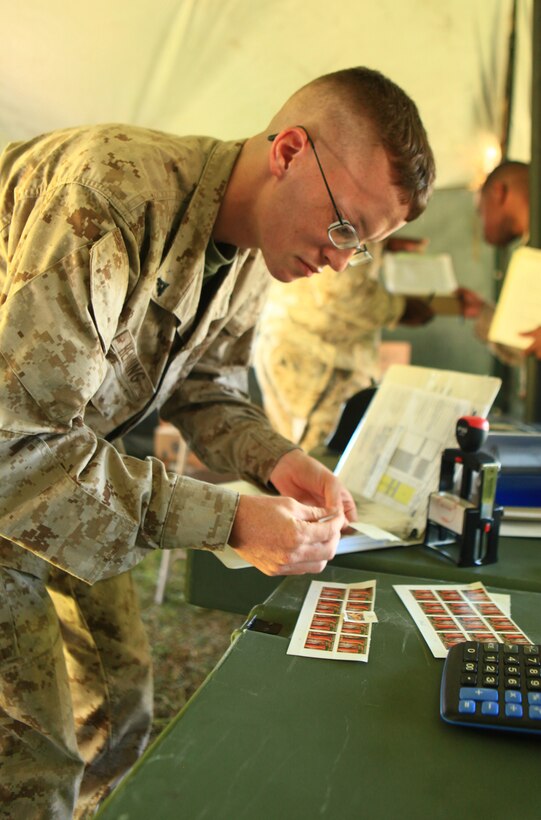Lance Cpl. Stephen Hemming, a postal clerk with Combat Logistics Regiment 2, 2nd Marine Logistics Group, prepares stamps for a customer at a field-expedient post office aboard Camp Lejeune, N.C., Sept 11, 2012. The post office served as a training environment where Marines such as Hemming could learn how to process mail in a deployed environment, where access to modern technologies can be limited or non-existent.  