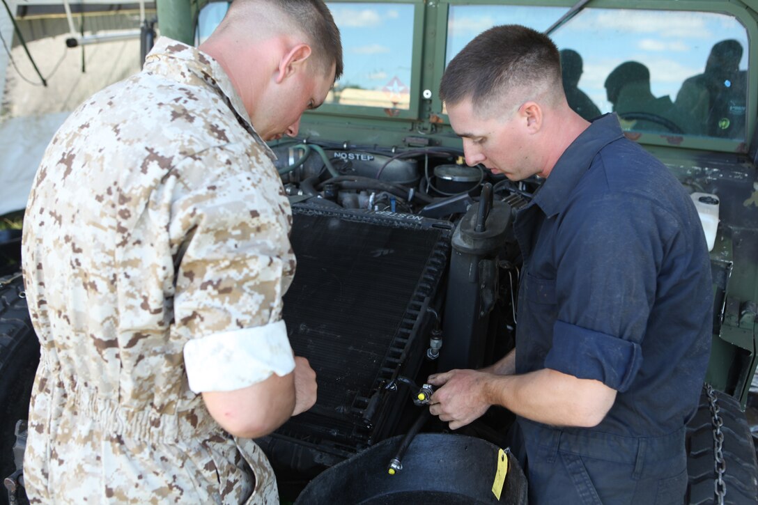 Two Marines with 2nd Maintenance Battalion, 2nd Marine Logistics Group install a Humvee engine Sept. 11, 2012, during a week-long field training exercise aboard Camp Lejeune, N.C. The Marines set up an Intermediate Maintenance Activity facility, which is a huge garage that provides the tools needed to repair almost any piece of gear Marines use.