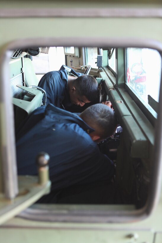 Two Marines with 2nd Maintenance Battalion, 2nd Marine Logistics Group install an Humvee engine during a training exercise aboard Camp Lejeune, N.C., Sept. 12, 2012.  The Marines set up an Intermediate Maintenance Activity facility, which is a huge garage that provides the tools needed to repair almost any piece of gear Marines use.